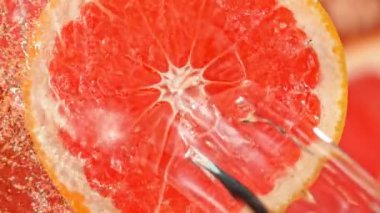 Super Slow Motion Shot of Splashing Water on Rotating Grapefruit Slice at 1000fps. Shooted with High Speed Cinema Camera at 4K.