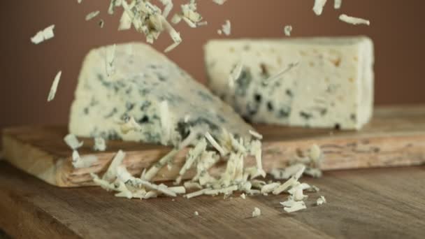 Super Slow Motion Shot Grated Blue Cheese Falling Wooden Board — Vídeos de Stock