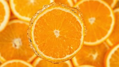 Super Slow Motion Shot of Splashing Water from Rotating Orange Slice at 1000fps. Shooted with High Speed Cinema Camera at 4K.