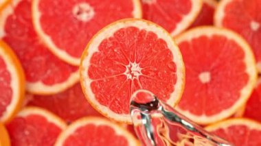 Super Slow Motion Shot of Splashing Water on Rotating Grapefruit Slice at 1000fps. Shooted with High Speed Cinema Camera at 4K.