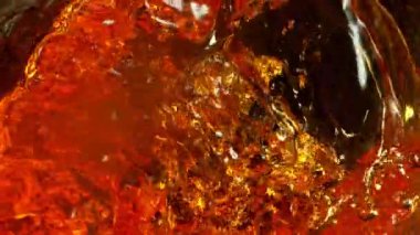 Super Slow Motion Detail Shot of Waving Golden Alcohol Liquid in Glass Bottle at 1000fps. Filmed with High Speed Cinema Camera at 4K.