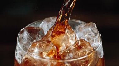 Super Slow Motion Shot of Pouring Fresh Cola Lemonade on Ice Cubes With Camera Motion at 1000fps. Filmed with High Speed Cinema Camera, 4k.