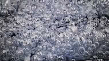Super Slow Motion Shot of Oil Bubbles in Blue Water at 1000fps. Filmed with High Speed Cinema Camera at 4K.