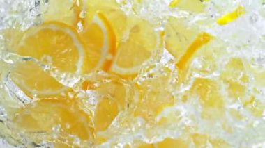 Süper Yavaş Çekim Taze Limon Dilimleri Yeşil Arkaplanda Su Girdabına 1000 fp hızla düşüyor. 4K 'da Yüksek Hız Sinema Kamerası ile çekildi..