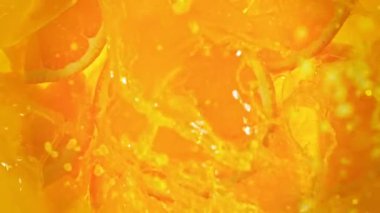 Süper Yavaş Çekim Taze Portakal Dilimleri Juice Whirl 'a 1000 fps hızla düşüyor. 4K 'da Yüksek Hız Sinema Kamerası ile çekildi..