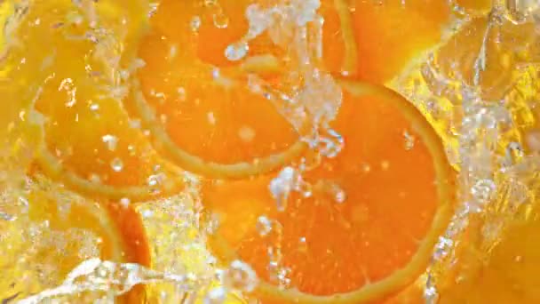 Super Slow Motion Shot Orange Slies Falling Water Whirl 1000 — стоковое видео