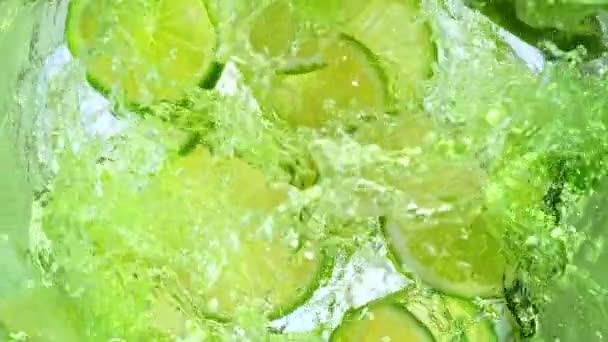 Super Slow Motion Shot Fresh Lime Plastry Wpadają Lemonade Whirl — Wideo stockowe