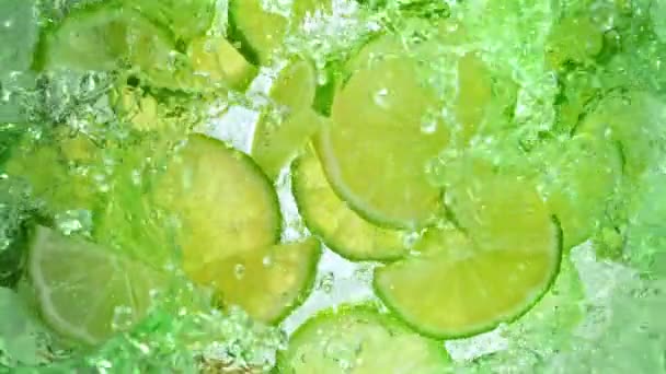 Super Slow Motion Shot Fresh Lime Plastry Wpadają Lemonade Whirl — Wideo stockowe