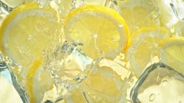 Limon dilimleri ve buz küplerine su sıçratma sahnesi. 4K 'da Yüksek Hız Sinema Kamerası ile çekildi..
