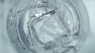 Süper Yavaş Hareket Detaylı Buz Küpünün 1000 fps 'lik votkayla bardağa düşüşü. 4K 'da Yüksek Hız Sinema Kamerası ile çekildi.