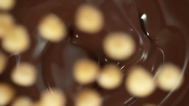 スーパースローモーション ピーレッドヘーゼルナッツのショット スウィリングメルトチョコレートに落ちる 1000 Fps 4Kで高速シネマカメラで撮影された — ストック動画