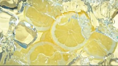 Limon dilimleri ve buz küplerine su sıçratma sahnesi. 4K 'da Yüksek Hız Sinema Kamerası ile çekildi..