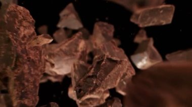 Ham Çikolata Parçalarının Süper Yavaş Çekimi. Kameraya doğru uçan parçacıklar. Yüksek Hız Sinema Kamerası, 4k.