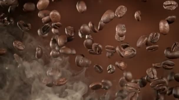 超级慢镜头飞行高级咖啡豆和烟在棕色背景下1000英尺每秒 用高速电影摄影机拍摄 — 图库视频影像