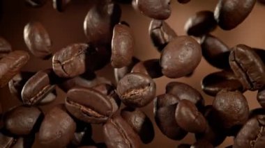 Kahverengi Soyut Arkaplan 'da Flying Premium Coffee Beans' in Süper Yavaş Film Macro Shot 'u. Yüksek Hız Sinema Kamerası, 4k.