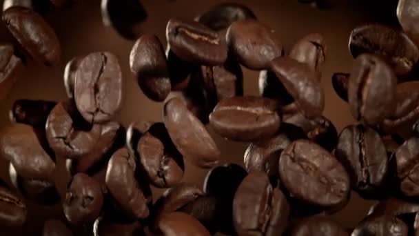 1000Fpsのブラウン抽象的な背景にあるフライングプレミアムコーヒー豆のスーパースローモーションマクロショット 高速シネマカメラで撮影 — ストック動画