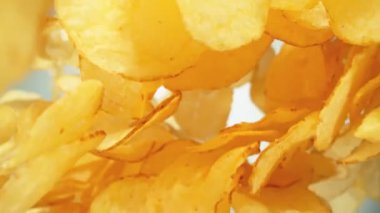 Super Slow Motion shot of Premium Patates Cipsleri Işık Arkaplanındaki kameraya doğru uçuyor. Yüksek Hız Sinema Kamerası, 4K.