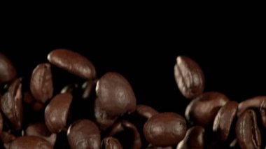 Super Slow Motion Macro shot 'ı Uçan Premium Kahve Fasulyeleri, Siyah Arka plan' da izole edildi. Yüksek Hız Sinema Kamerası, 4k.