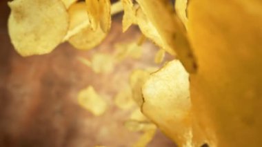 Süper Yavaş Çekim Patates Cipsleri Soyut Kahverengi Arkaplan 'a 1000fps hızla düşüyor. Yüksek Hız Sinema Kamerası, 4K.