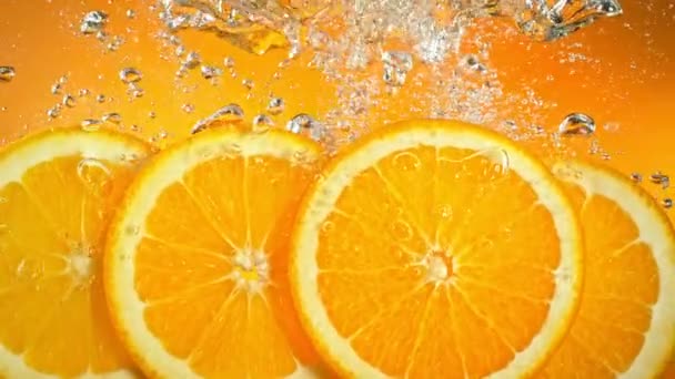 Super Slow Motion Shot Verse Sinaasappelschijfjes Vallen Stromen Het Water — Stockvideo