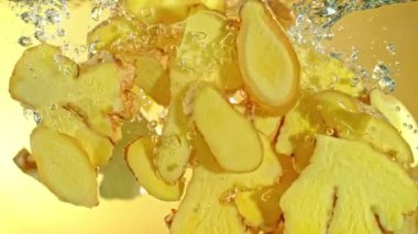 Ginger Dilimlerinin suya düşüşünün Süper Yavaş Çekimi. Yüksek Hız Sinema Kamerası, 4K.