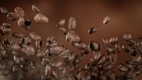 超级慢镜头飞行高级咖啡豆和烟在棕色背景下1000英尺每秒 用高速电影摄影机拍摄 — 图库视频影像