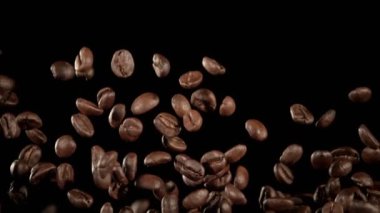 Super Slow Motion Macro shot 'ı Uçan Premium Kahve Fasulyeleri, Siyah Arka plan' da izole edildi. Yüksek Hız Sinema Kamerası, 4k.