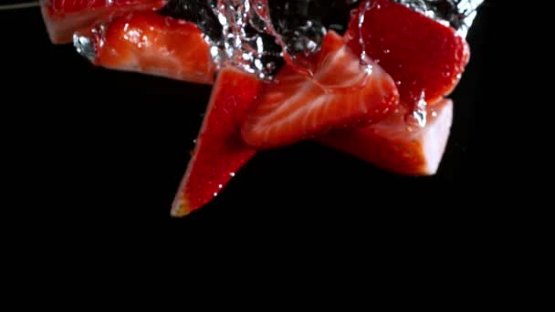 超慢速运动的草莓切割机落水和在水中流动 以1000发的速度隔离在黑暗中 用4K解像度的高速电影摄影机拍摄 — 图库视频影像