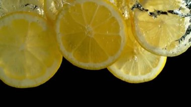Taze Limon Dilimlerinin Süper Yavaş Çekimi Siyah Arkaplanda 1000 fps hızla Düşüyor ve Akıyor. 4K Çözünürlükte Yüksek Hız Sinema Kamerası ile Çekim.