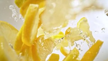 Süper Yavaş Çekim Taze Limon Dilimleri ve ardından Kamera 1000 fps hızla suya sıçrıyor. Yüksek Hız Sinema Kamerası, 4K.