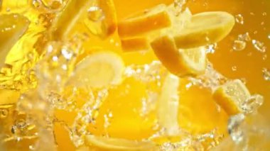 Süper Yavaş Çekim Taze Limon Dilimleri ve ardından Kamera 1000 fps hızla suya sıçrıyor. Yüksek Hız Sinema Kamerası, 4K.