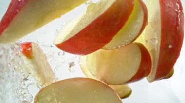 Kırmızı Elma Kesikleri 'nin Süper Yavaş Çekimi ve ardından 1000 fps hızla suya sıçrayan Kamera. Yüksek Hız Sinema Kamerası, 4K.