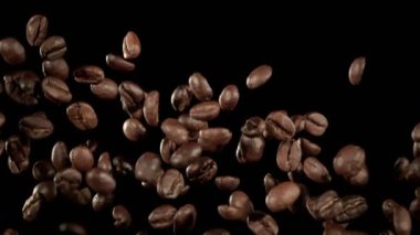 Super Slow Motion Macro shot 'ı Uçan Premium Kahve Fasulyeleri, Siyah Arka plan' da izole edildi. Yüksek Hız Sinema Kamerası, 4k.