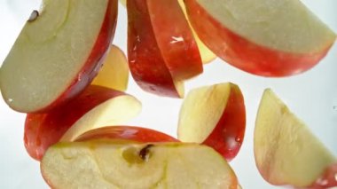 Kırmızı Elma Kesikleri 'nin Süper Yavaş Çekimi ve ardından 1000 fps hızla suya sıçrayan Kamera. Yüksek Hız Sinema Kamerası, 4K.