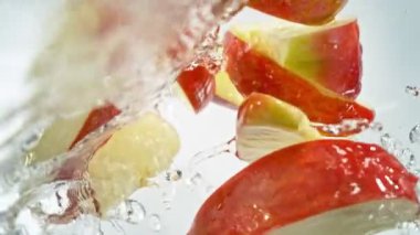 Kırmızı Elma Kesikleri 'nin Süper Yavaş Çekimi ve ardından 1000 fps hızla suya sıçrayan Kamera. Yüksek Hız Sinema Kamerası, 4K.
