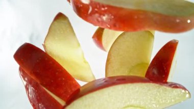 Kırmızı Elma Kesikleri 'nin Süper Yavaş Çekimi ve ardından 1000 fps hızla suya sıçrayan Kamera. Yüksek Hız Sinema Kamerası, 4K.