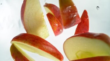 Kırmızı Elma Kesikleri 'nin Süper Yavaş Çekimi ve ardından 1000 fps hızla suya sıçrayan Kamera. Yüksek Hız Sinema Kamerası, 4K.