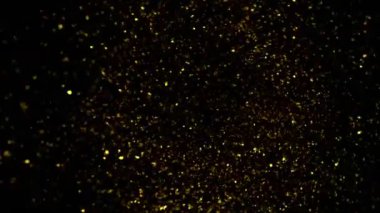 Süper Yavaş Çekim Altın Parıldayan Parçacıklar. Siyah üzerine izole edilmiş ve yüksek hızlı sinema kamerasıyla çekilmiş, 4K.