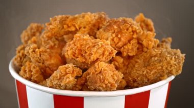 Yavaş Çekim Kızarmış Tavuk Parçaları ve Gri Arkaplanda Kova İçinde Dönen Duman Çekimi. Yüksek Hız Sinema Kamerası, 4K.