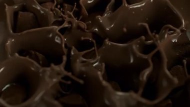 Süper Yavaş Çekim Çiğ Çikolata Parçacıkları Eritilmiş Çikolata 'nın içine 1000 fps hızla düşüyor. Yüksek Hız Sinema Kamerası, 4K.