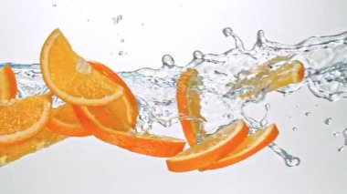 Portakal Dilimlerinin Süper Yavaş Hareketi Beyaz Arkaplanda Su Sıçratarak Uçuyor. Yüksek Hız Sinema Kamerası, 4K.