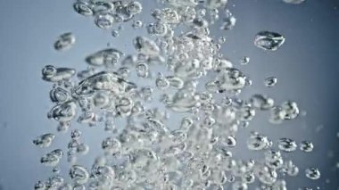 Hava kabarcıklarının Süper Yavaş Çekimi Açık Mavi Arkaplan 'da Suda Yükseliyor. Yüksek Hız Sinema Kamerası, 4K.