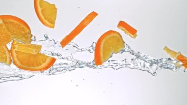Portakal Dilimlerinin Süper Yavaş Hareketi Beyaz Arkaplanda Su Sıçratarak Uçuyor. Yüksek Hız Sinema Kamerası, 4K.