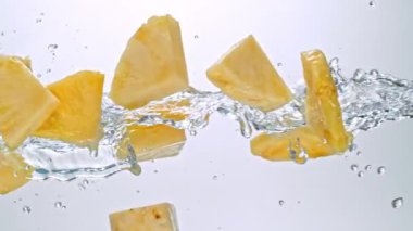 Pineapple Dilimlerinin Süper Yavaş Hareketi Beyaz Arkaplanda Su Sıçratarak Uçuyor. Yüksek Hız Sinema Kamerası, 4K.