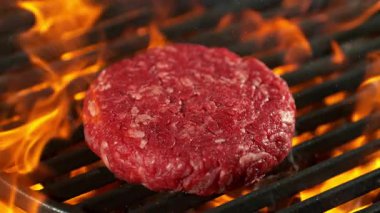 Süper Yavaş Çekim Hamburger Etleri Alevler ve Közlerle Sıcak Izgaraya Düşüyor. Yüksek Hız Sinema Kamerası, 4K.