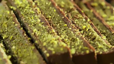 Ezilmiş Pistachios 'un Süper Yavaş Hareketi Dubai Çikolata Parçalarının üzerine düşüyor. Yüksek Hız Sinema Kamerası, 4K.