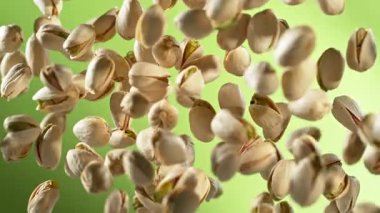 Süper Yavaş Çekim Taze Fıstıklı Fındık Yeşil Arkaplanda Uçuyor. Yüksek Hız Sinema Kamerası, 4K.