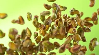 Taze Soyulmuş Pistachio Fındıklarının Süper Yavaş Çekimi. Yeşil Arka planda Uçuyor. Yüksek Hız Sinema Kamerası, 4K.
