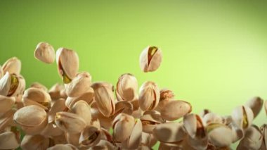 Süper Yavaş Çekim Taze Fıstıklı Fındık Yeşil Arkaplanda Uçuyor. Yüksek Hız Sinema Kamerası, 4K.