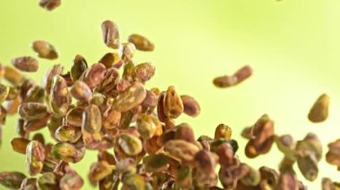 Taze Soyulmuş Pistachio Fındıklarının Süper Yavaş Çekimi. Yeşil Arka planda Uçuyor. Yüksek Hız Sinema Kamerası, 4K.